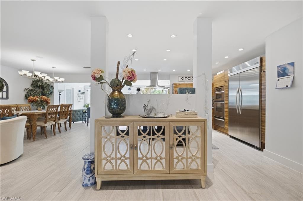 Open-concept interior featuring light wood-finish flooring, recessed lighting, and a neutral color palette