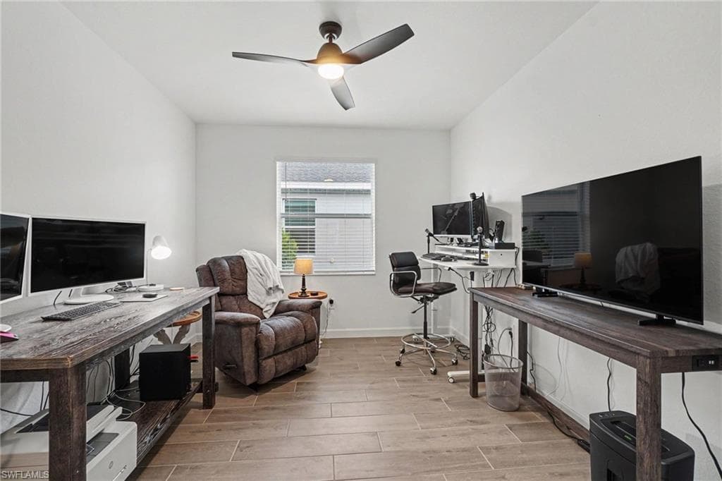 Room featuring wood-look tile flooring, white painted walls, and a ceiling fan with integrated lighting