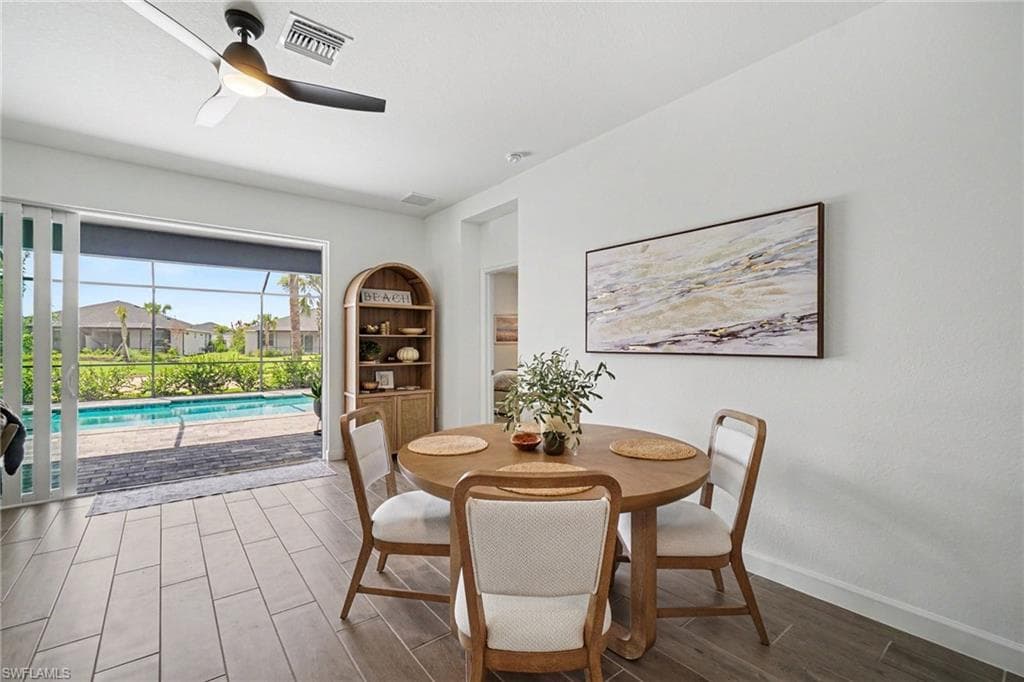 Contemporary dining area with wood-finish tile flooring and a ceiling fan