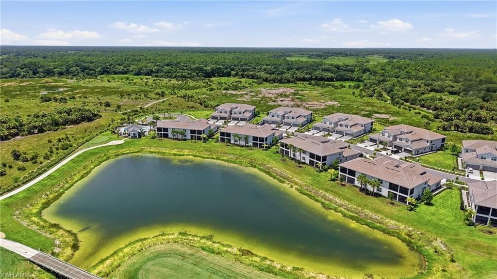 Lakeside community featuring multiple residential buildings with tile roofs and screened balconies