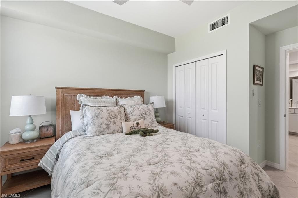 Bedroom featuring a wood-finish headboard, bifold closet doors, and light-toned wall paint