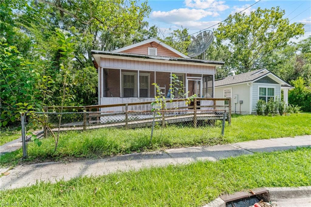 Front elevation featuring a screened porch, wood siding, and a ramp entrance