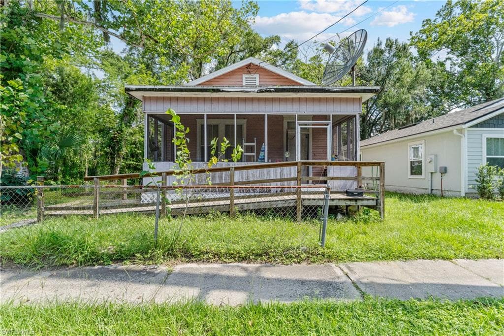 Exterior featuring a screened porch with a wooden ramp, shiplap siding, and a gable roofline