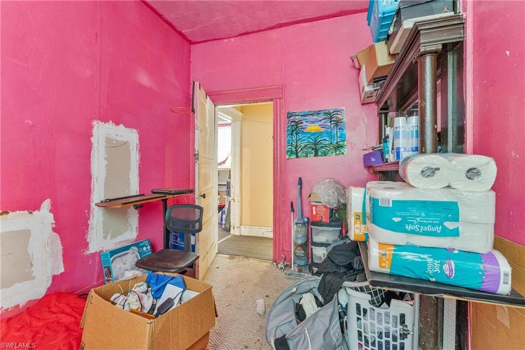 Room with pink walls and a doorway leading to an additional space