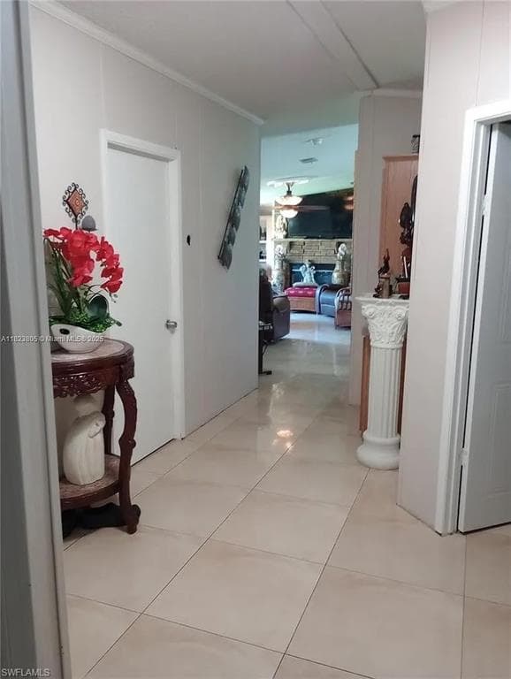 Hallway featuring light-toned tile flooring, white paneled walls, and white trim