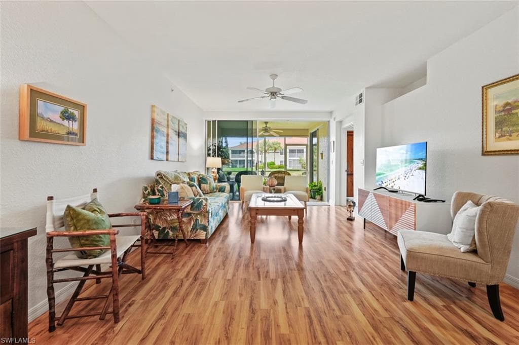 Living room with ceiling fan and light hardwood / wood-style flooring