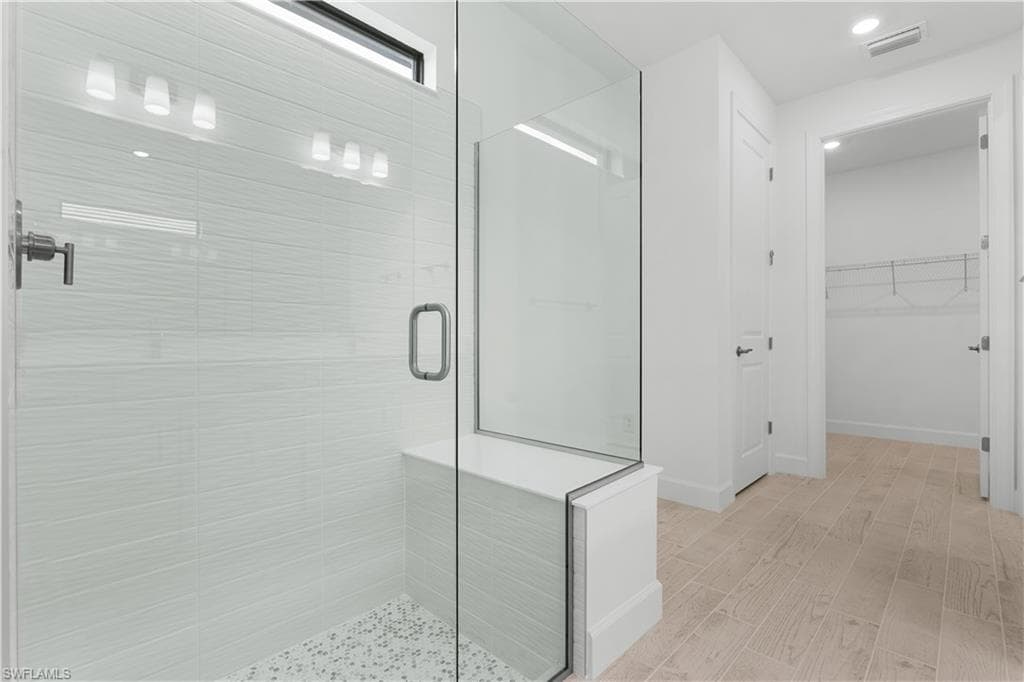 view of primary bathroom leading into spacious closet
