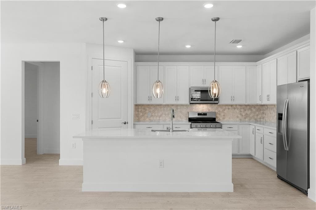 quartz countertops, tile backsplash stainless steel appliances and pantry