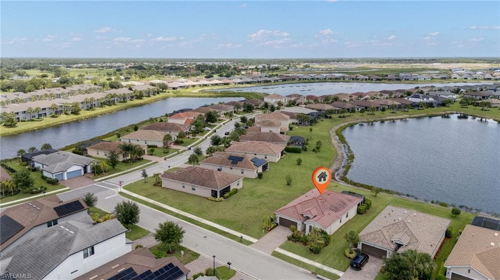 Aerial overview showcasing a residential property with a tile roof and an attached two-car garage