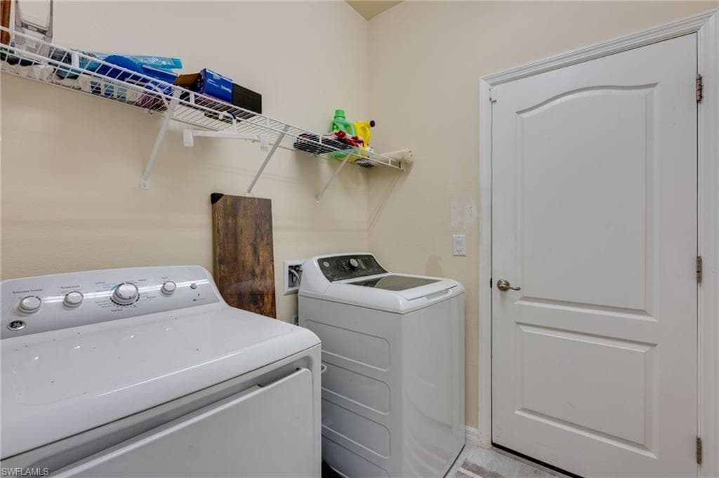 Dedicated utility area featuring overhead wire shelving and a paneled door with brushed nickel hardware
