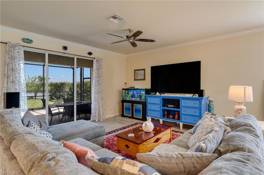 Living area featuring wood-finish flooring, crown molding, and a ceiling fan with integrated lighting
