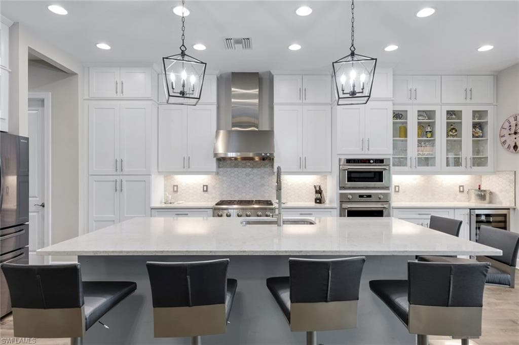 Expansive kitchen island with seating for four, complemented by white shaker cabinetry