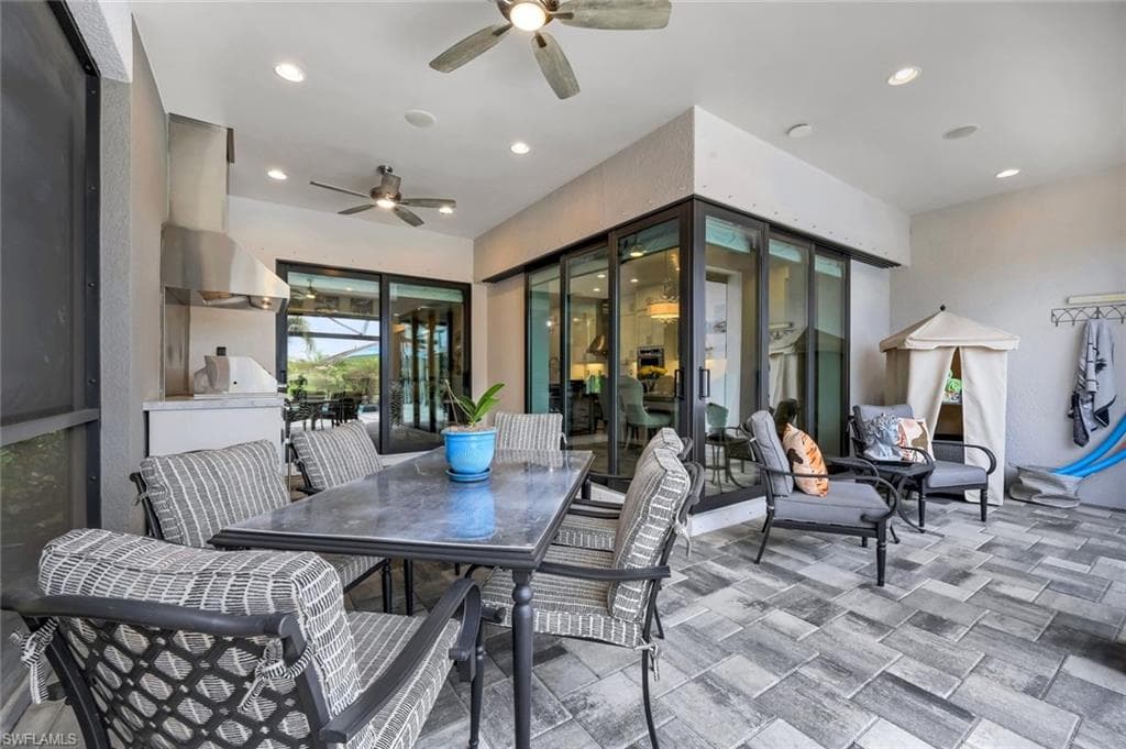 Expansive screened patio featuring wood-finish tile flooring, recessed lighting, and ceiling fans