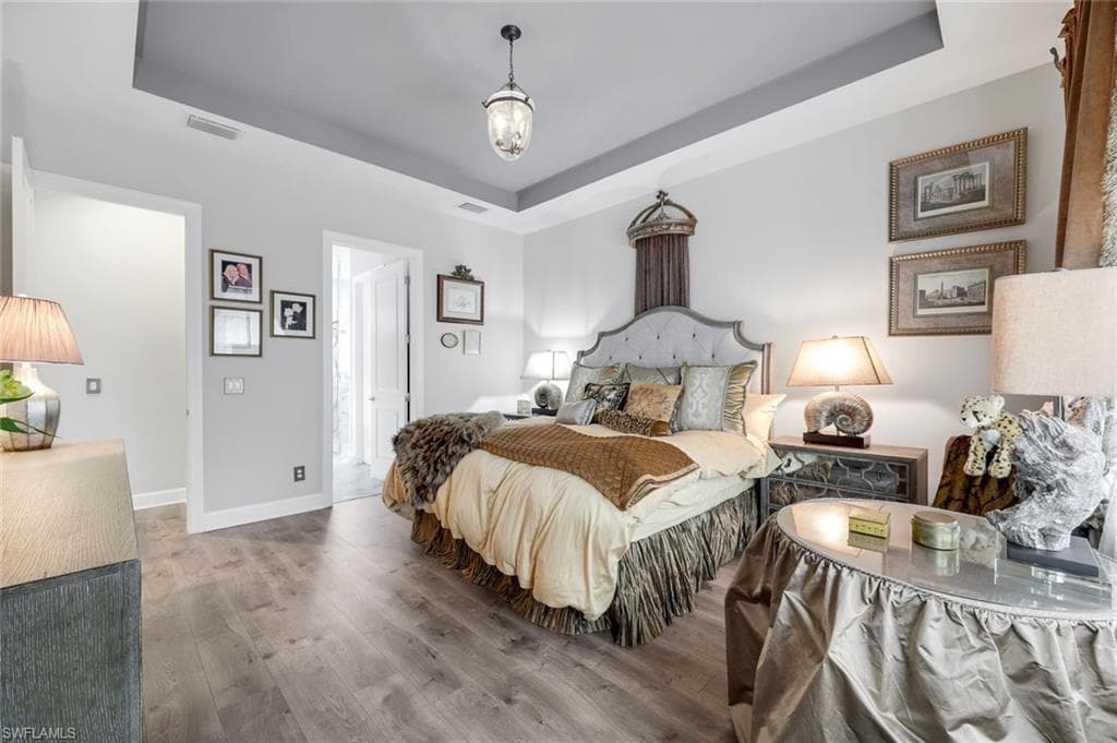 Tray ceiling with recessed lighting and a central pendant fixture