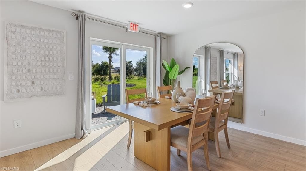 Model home. Dining space featuring light wood-style floors, recessed lighting, and arched walkways