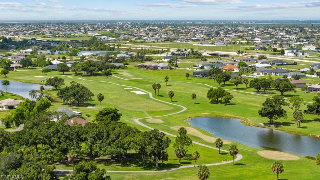 Expansive golf course setting featuring manicured greens and multiple water features