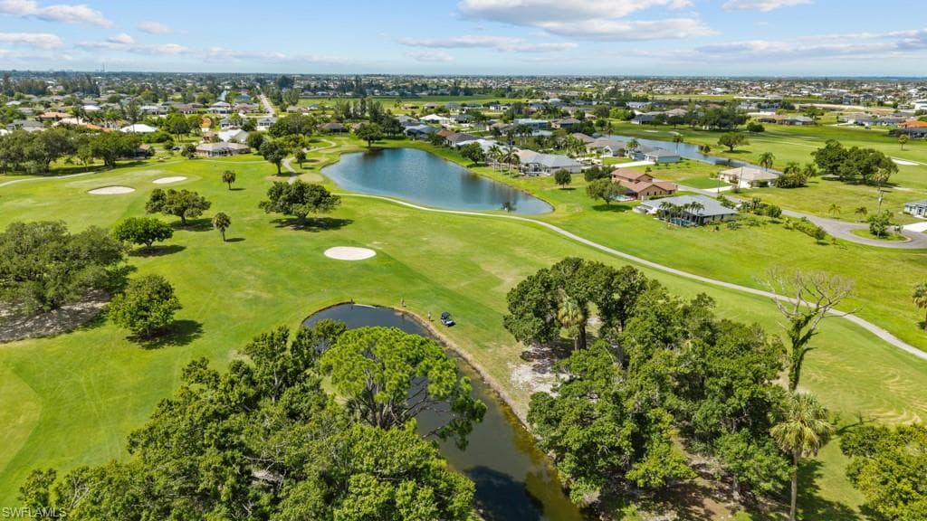 Expansive golf course setting featuring multiple greens, sand traps, and water features