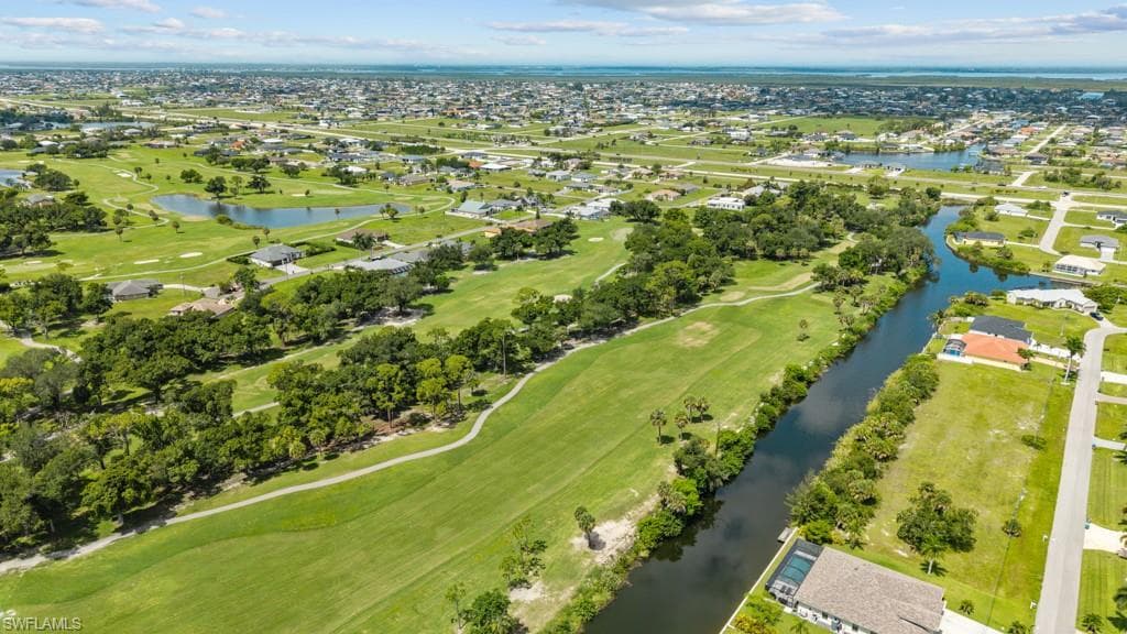 Expansive golf course property featuring green fairways, mature trees, and multiple water features