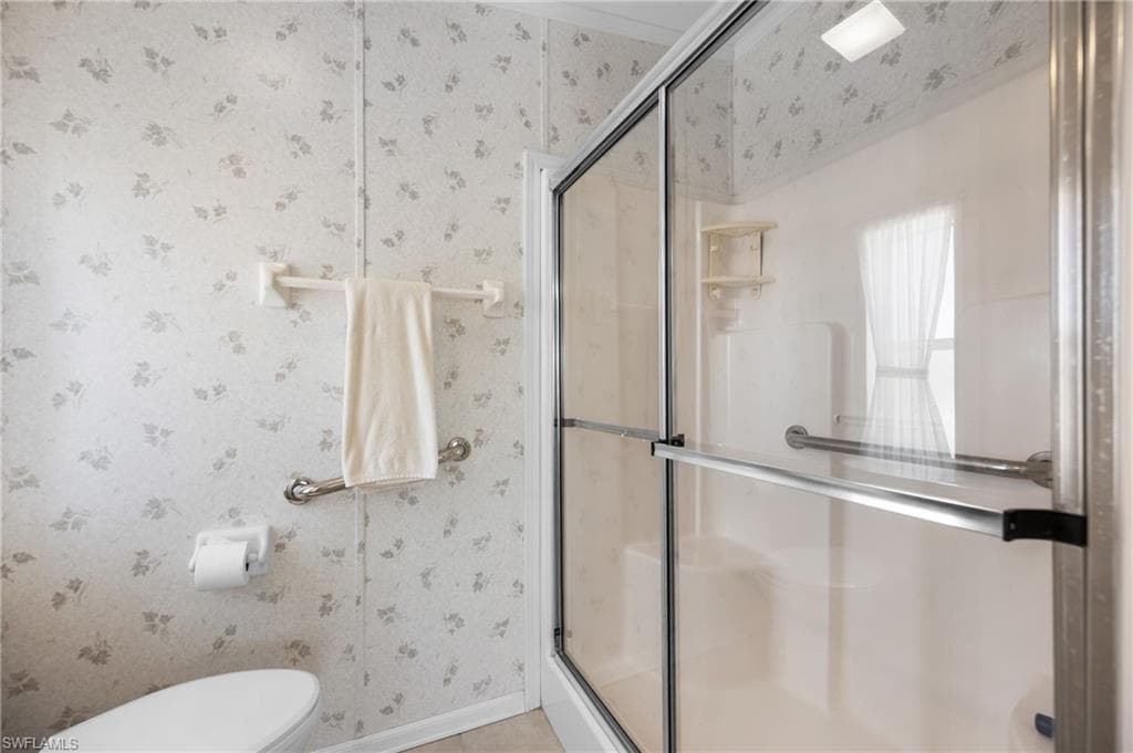 Walk-in shower with clear glass enclosure and chrome hardware