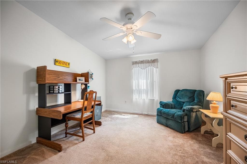 Carpeted room featuring white walls, a ceiling fan with integrated lighting, and a window with sheer curtains