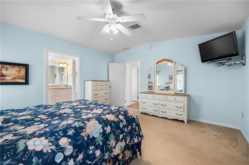 Spacious bedroom featuring light blue walls and neutral carpet flooring
