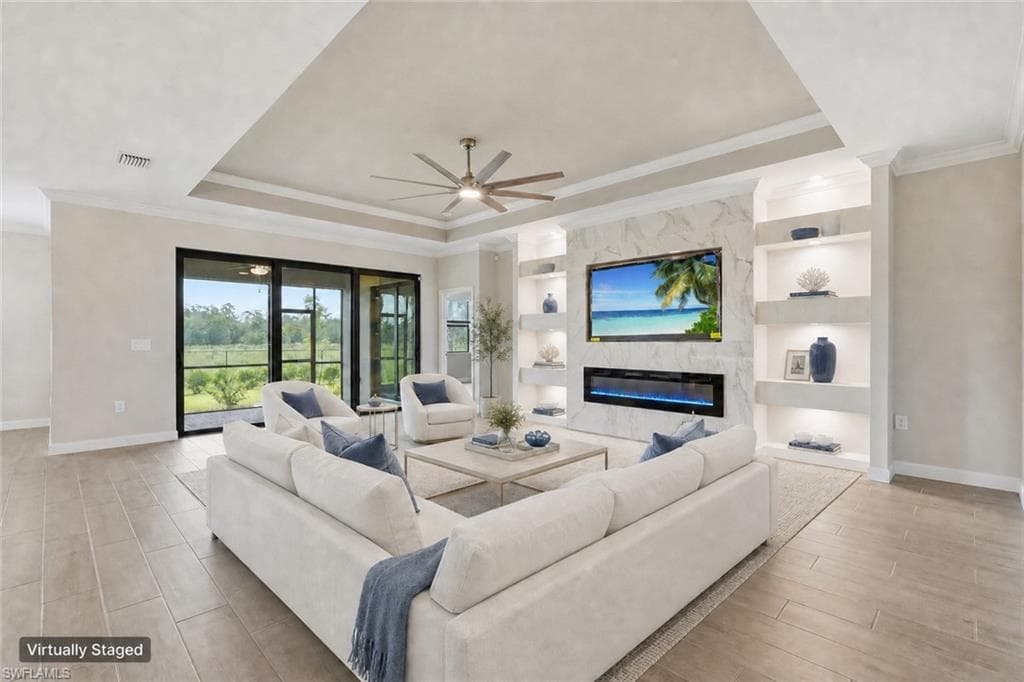 Spacious living area featuring coffered ceilings, wood-finish flooring, a contemporary ceiling fan, and a built-in media wall with shelving and an electric fireplace