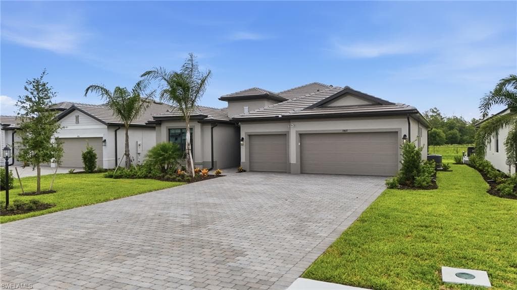 Contemporary single-story residence featuring a paver driveway, two-car garage, and a tiled roof