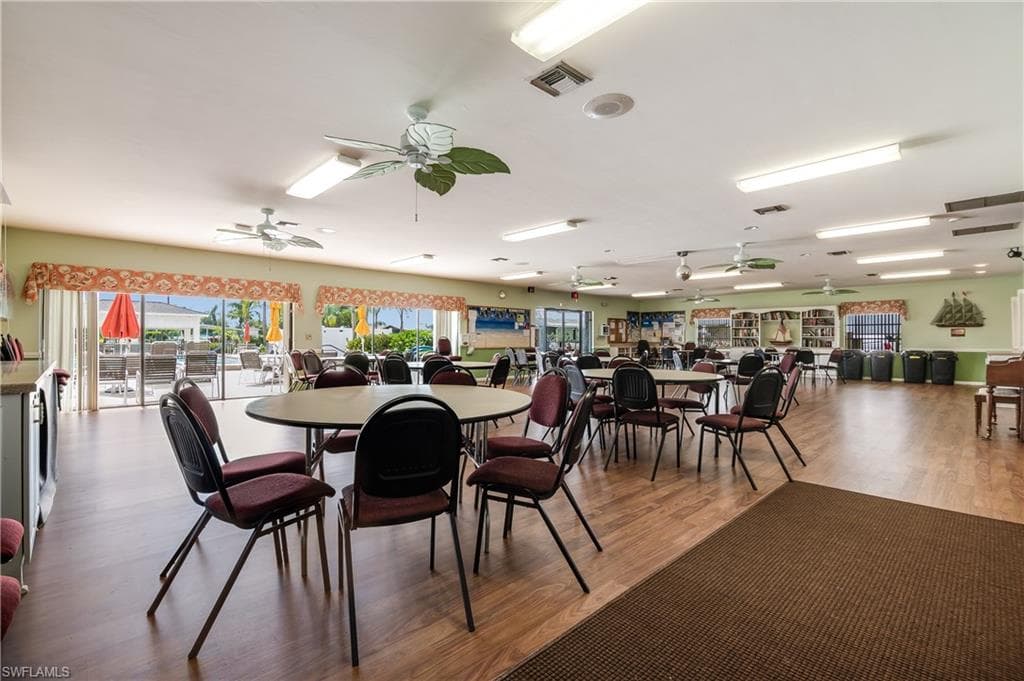 Spacious common area featuring wood-finish flooring and multiple ceiling fans