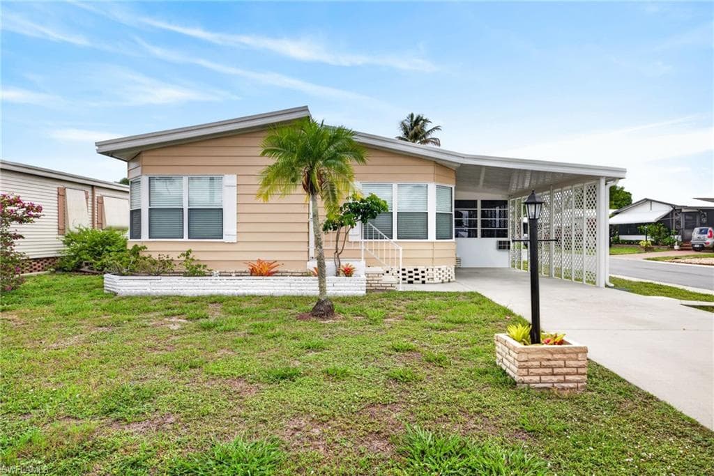 Single-story residence featuring horizontal siding, a covered carport, and a concrete driveway