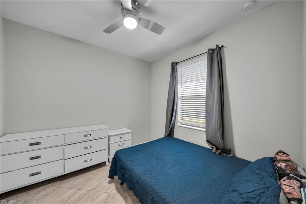 Bedroom with light tile patterned flooring and a ceiling fan