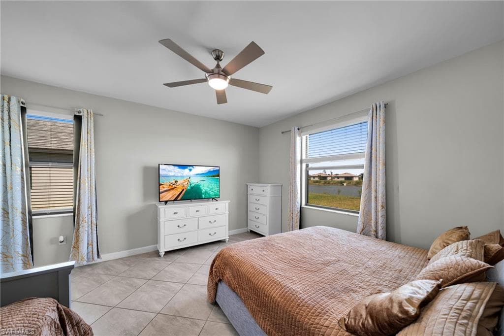 Bedroom featuring baseboards, ceiling fan, and light tile patterned floors
