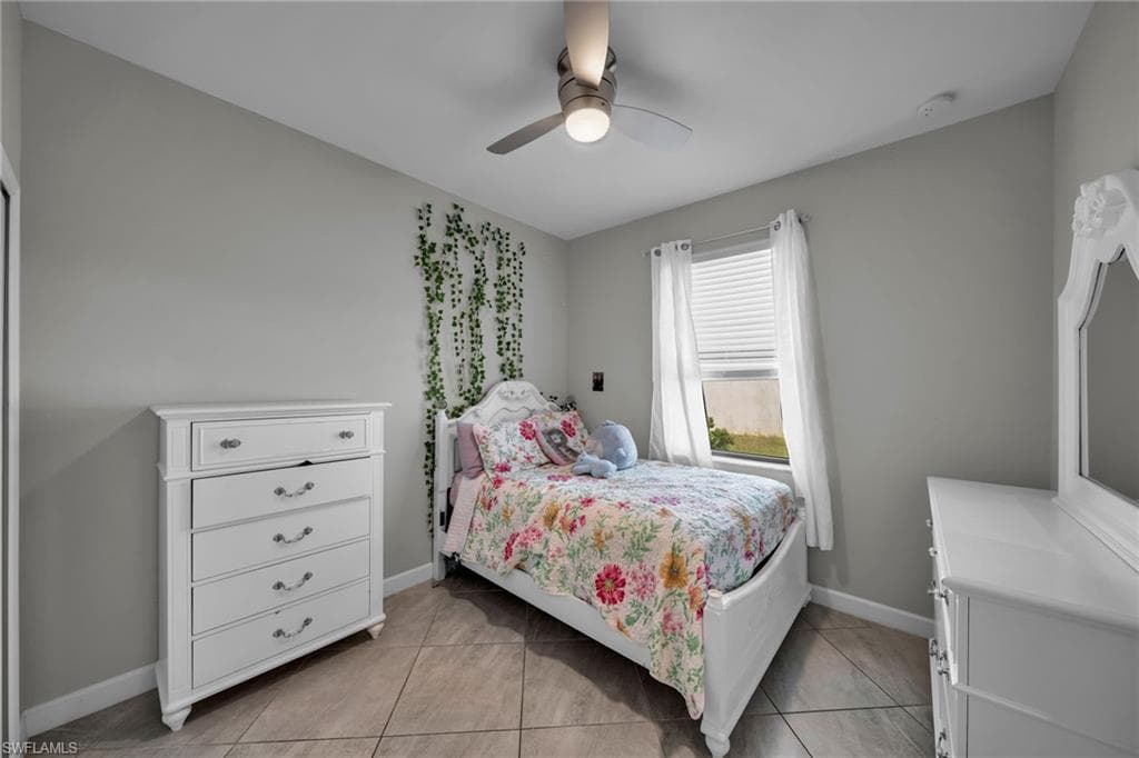 Bedroom with baseboards, ceiling fan, and light tile patterned floors