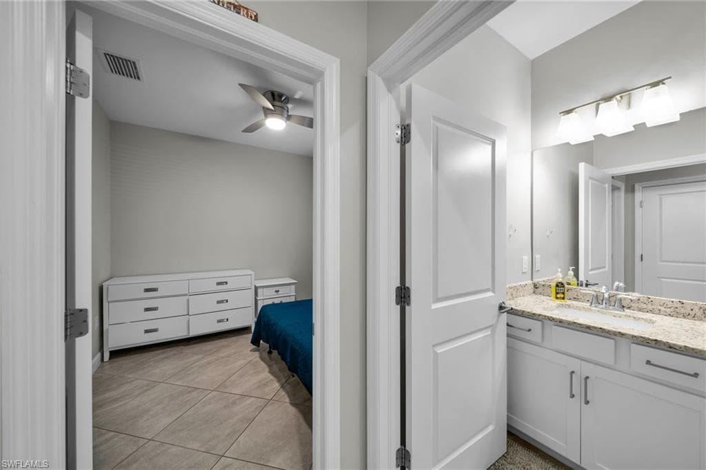 Bathroom with a ceiling fan, vanity, tile patterned floors, and visible vents