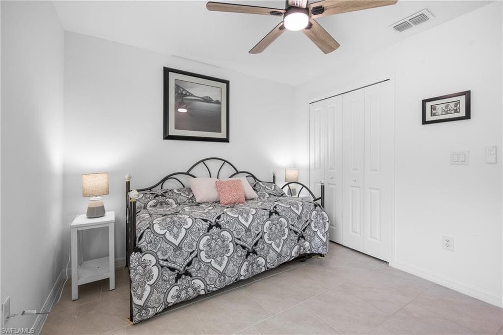 Neutral-toned tile flooring complements a ceiling fan with integrated lighting