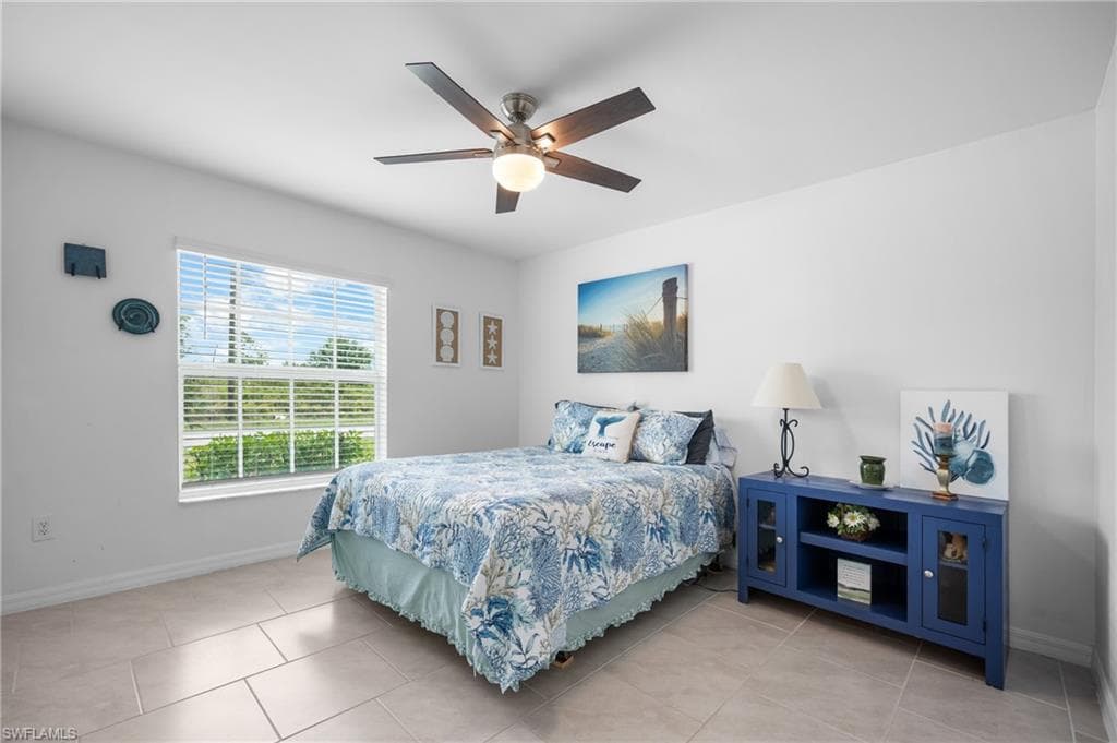 Room featuring light-colored tile flooring, white walls, a window with horizontal blinds, and a ceiling fan with integrated lighting