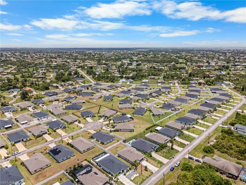 Residential neighborhood featuring single-story homes with dark roofs and light-colored exteriors