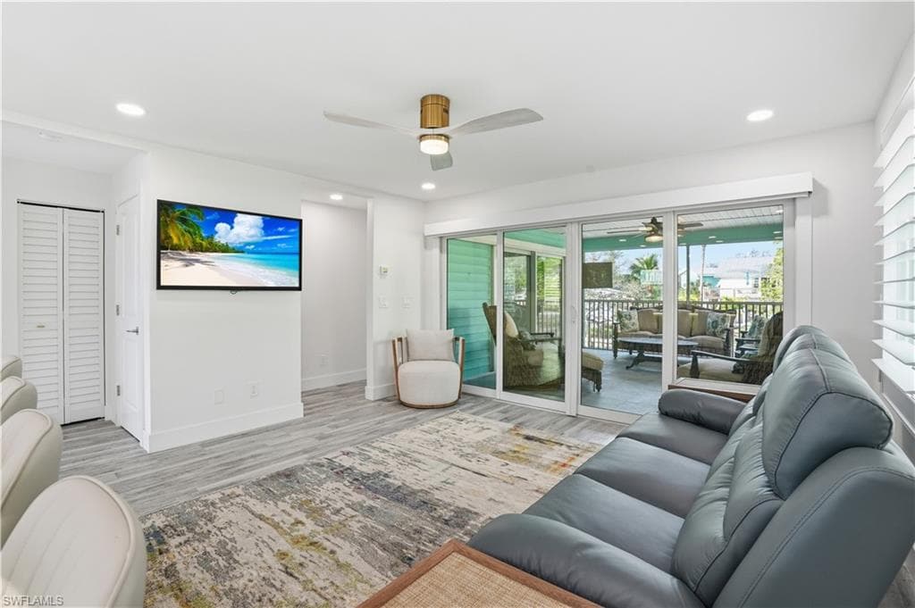 Living area featuring a ceiling fan, recessed lighting, and wood finished floors - Virtually Edited Image