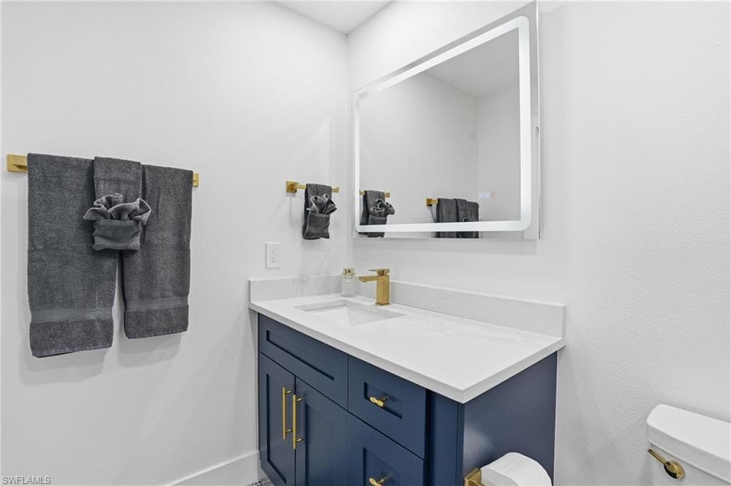 Half bath featuring vanity and toilet - Virtually Edited Image