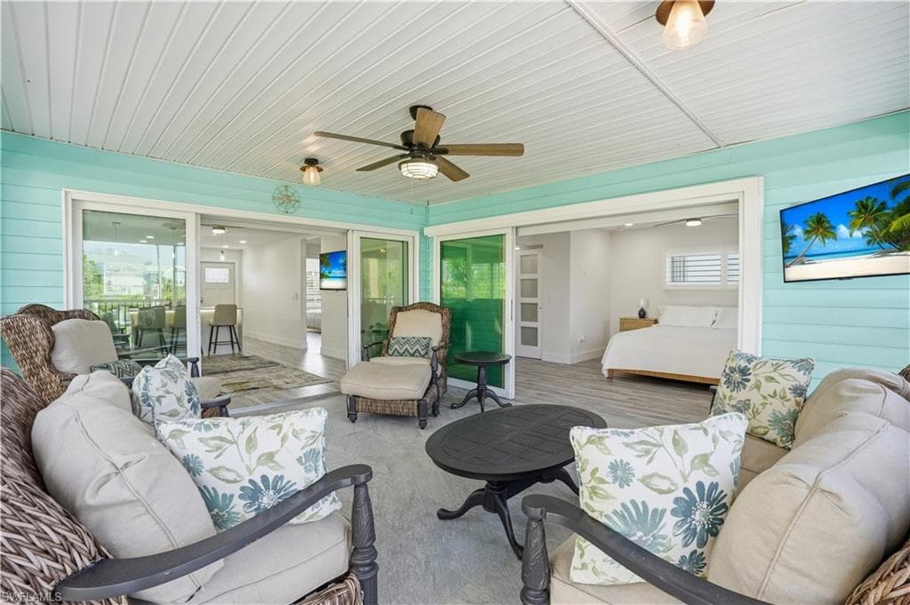 Sunroom featuring outdoor lounge area, ceiling fan, and healthy amount of natural light - Virtually Edited Image