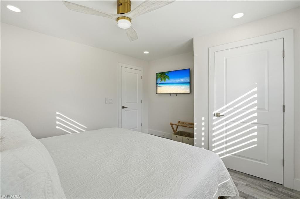 Bedroom featuring recessed lighting, wood finished floors, and ceiling fan - Virtually Edited Image