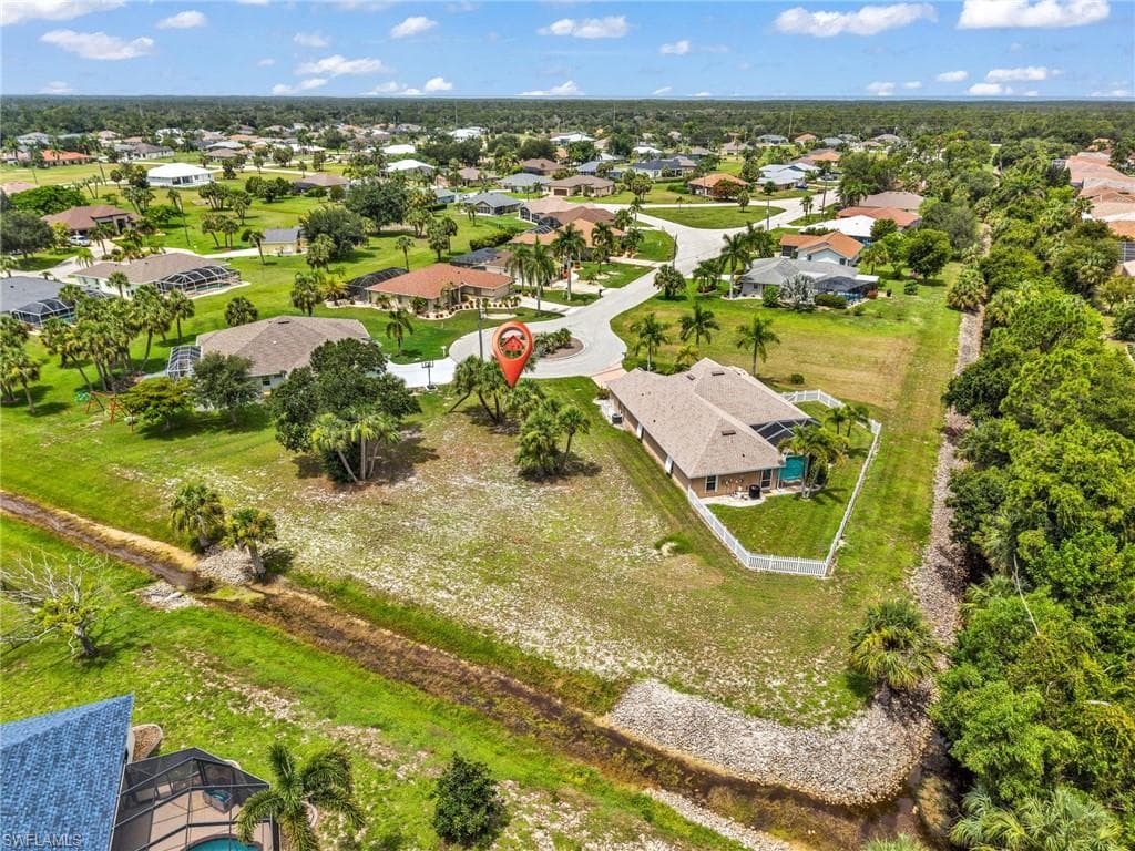 Spacious residential lot with verdant landscaping, mature palm trees, and a bordering waterway