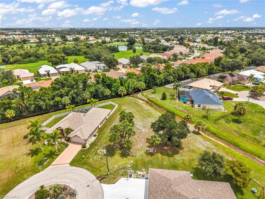 Aerial view showcasing a residential area with a prominent golf course and multiple water features