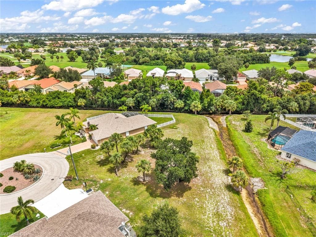 Expansive corner lot featuring a circular driveway and mature landscaping