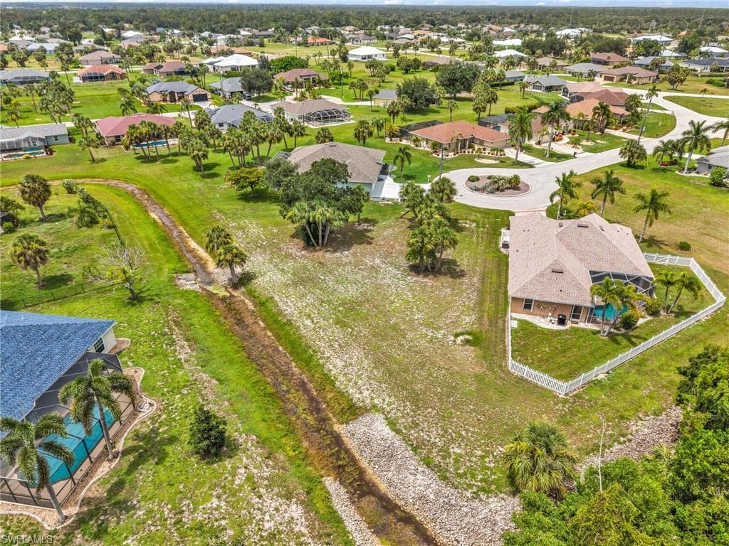 Expansive residential property featuring a screened-in swimming pool and a white privacy fence
