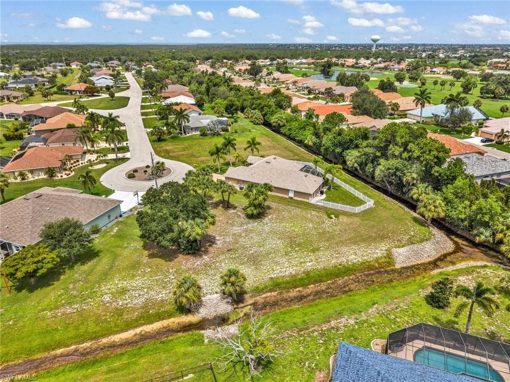Expansive residential lot featuring a cul-de-sac location, mature palm trees, and a waterway border