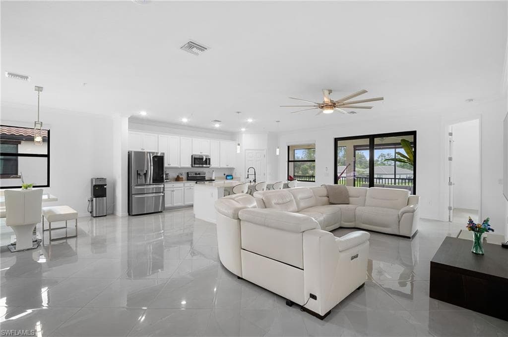 Open-concept living space with large format tile flooring and recessed lighting