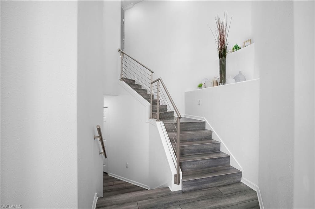 Staircase featuring wood-finish treads and risers with a stainless steel cable railing system