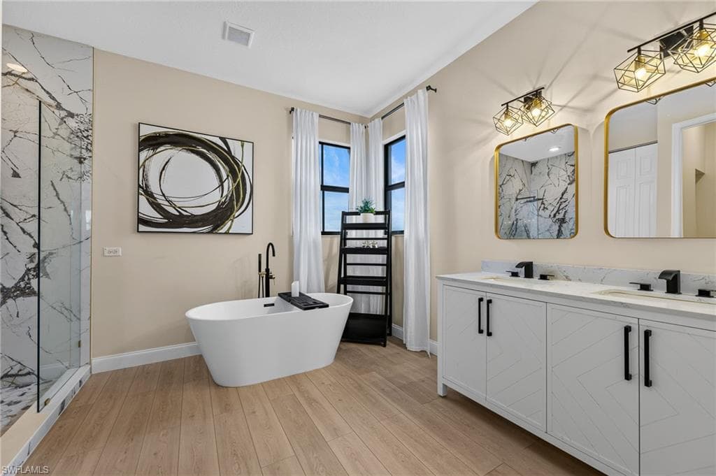 Primary bathroom featuring a freestanding soaking tub with a floor-mounted faucet