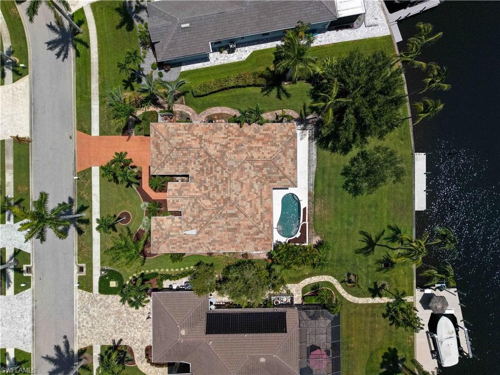 Property featuring a tile roof, a private swimming pool, and a waterfront location with a boat dock
