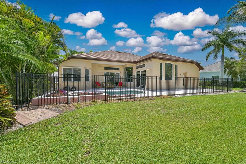 Expansive backyard featuring a fenced pool and spa area with paver decking